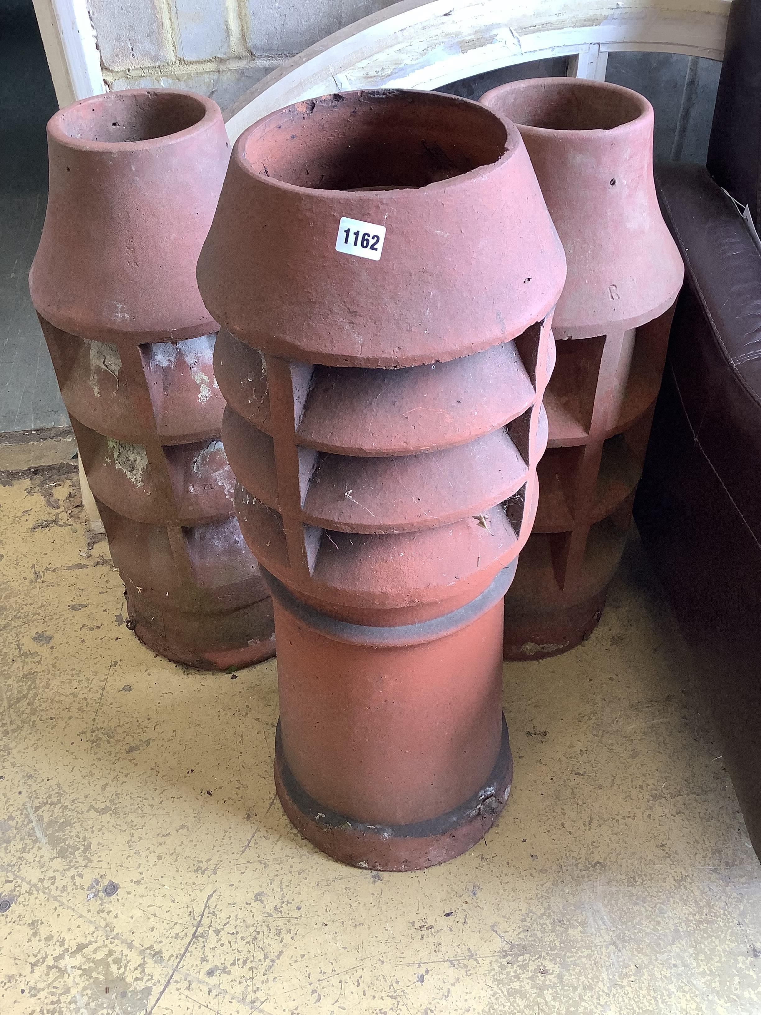 Three vintage terracotta chimney pots, largest 84cm high